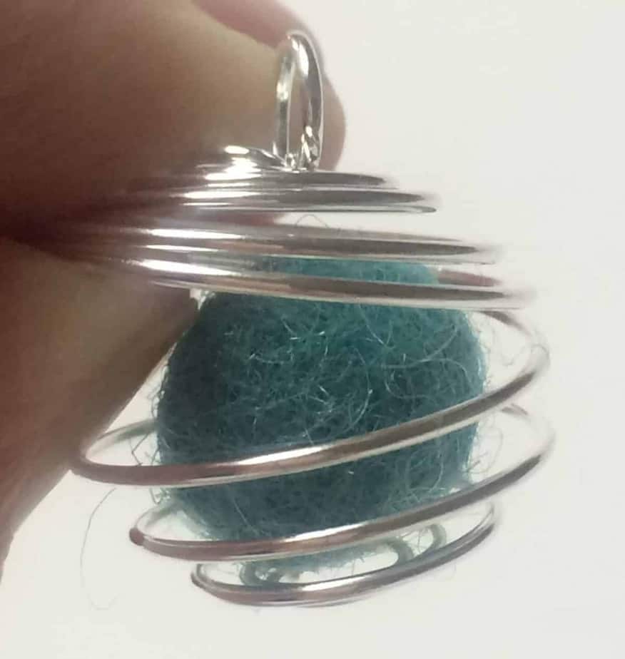 wool felt ball inside of wire cage pendant