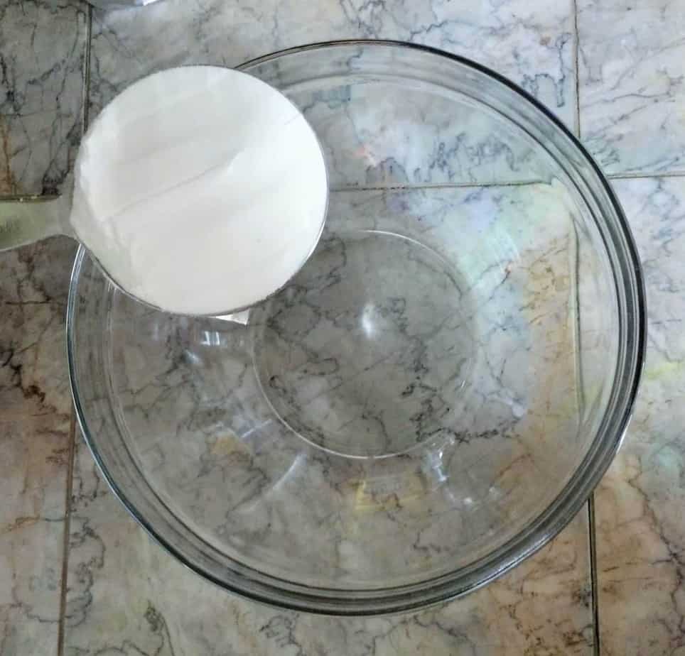 adding baking soda to glass mixing bowl