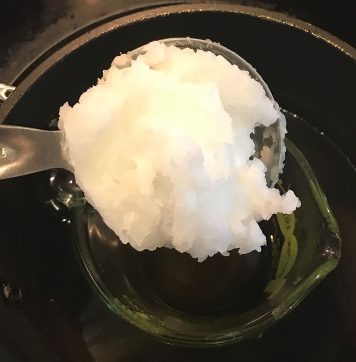 coconut oil being added to melted beeswax