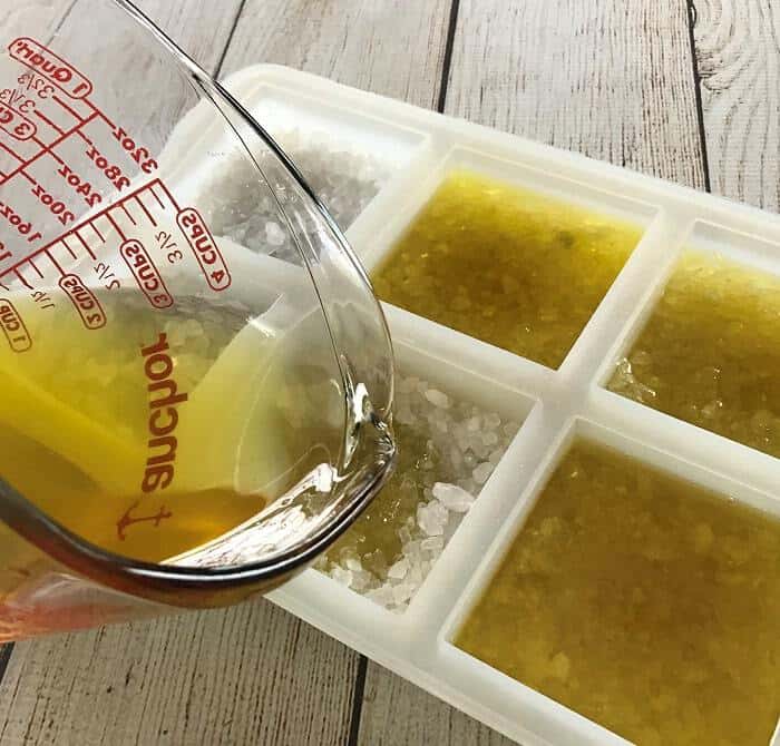 pouring melted butter and essential oil mixture over rock salt