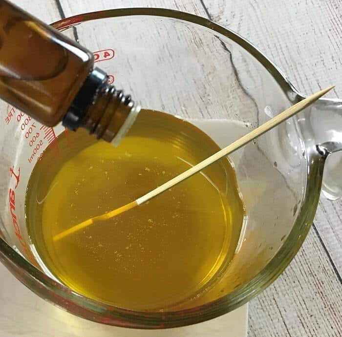 adding essential oil to melted butters and oil