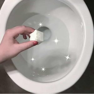 hand placing essential oil cleaning pod in toilet