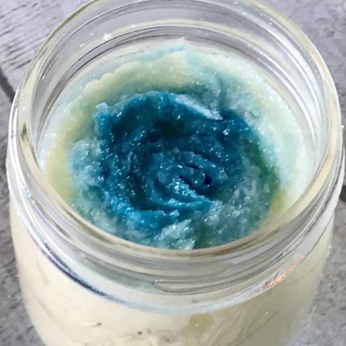 Copycat Lush Ocean Salt scrub recipe made with essential oils in clear jar with ocean blue layer across top