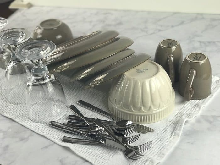 sparkling clean dishes drying on the counter after being washed with homemade essential oil dish soap