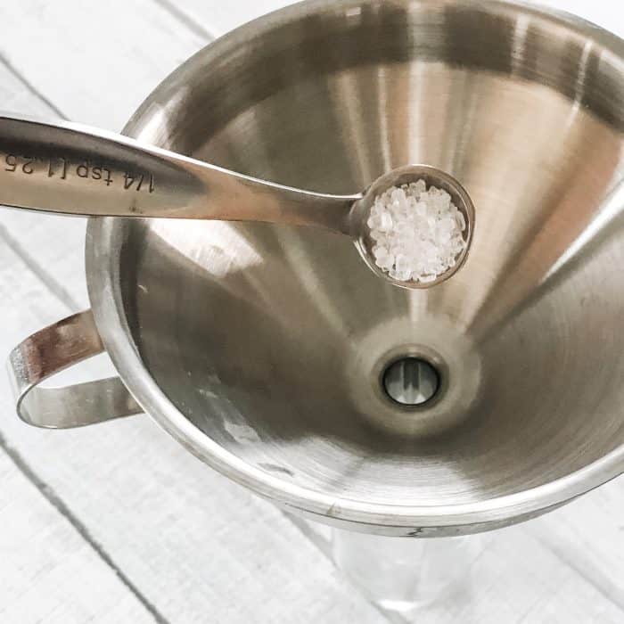 using funnel to add Epsom salt to 4 oz spray bottle