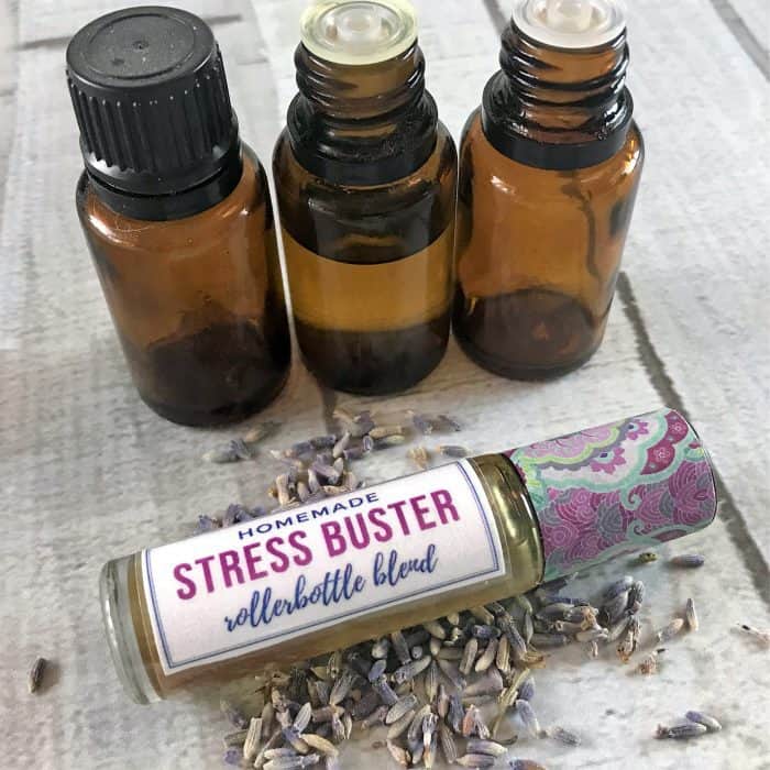 homemade stress buster rollerbottle blend with lavender buds and three essential oil bottle