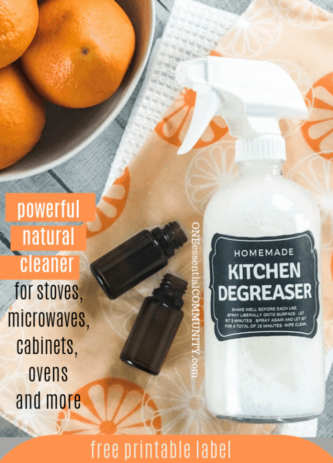 homemade kitchen degreaser spary with 2 essential oil bottles beside a bowl of oranges