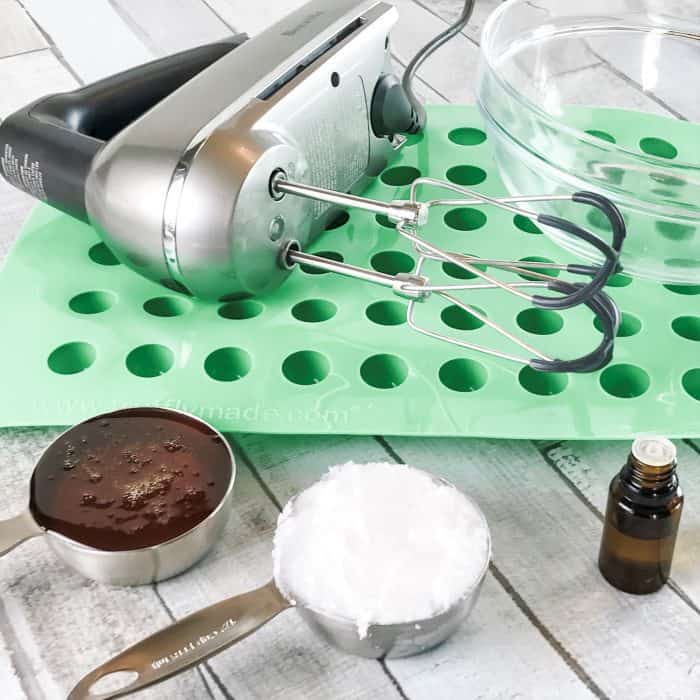 supplies to make homemade cough drops: hand mixer, silicone candy mold, honey, coconut oil, and essential oil