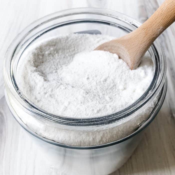 wooden spoon stirring natural homemade laundry soap so that all ingredients are mixed well