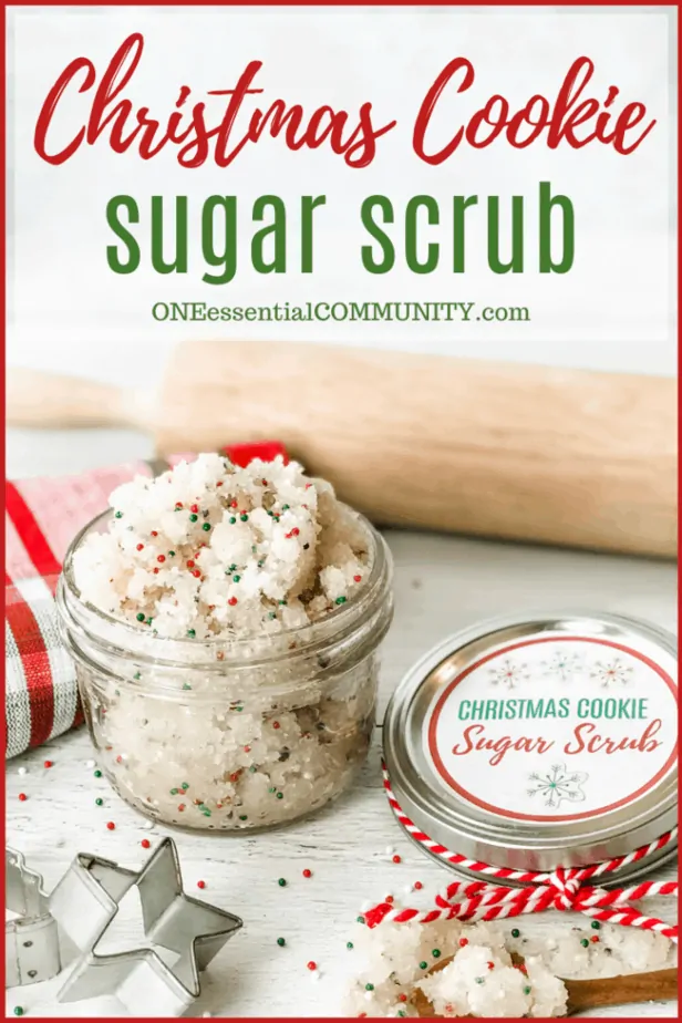 Christmas Cookie Sugar Scrub in glass jar next to lid with custom label, accented with rolling pin, cookie cutter, wooden spoon with additional scrub