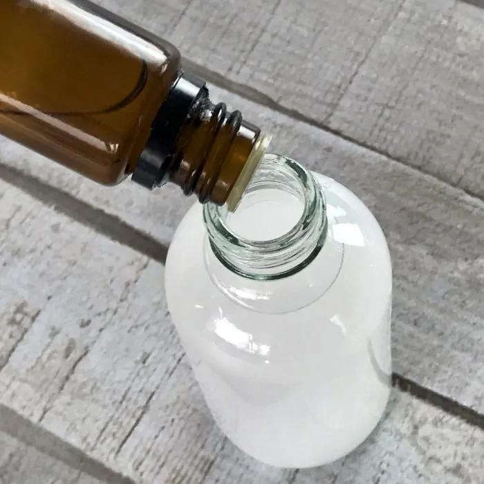 essential oil being added to DIY dry shampoo spray