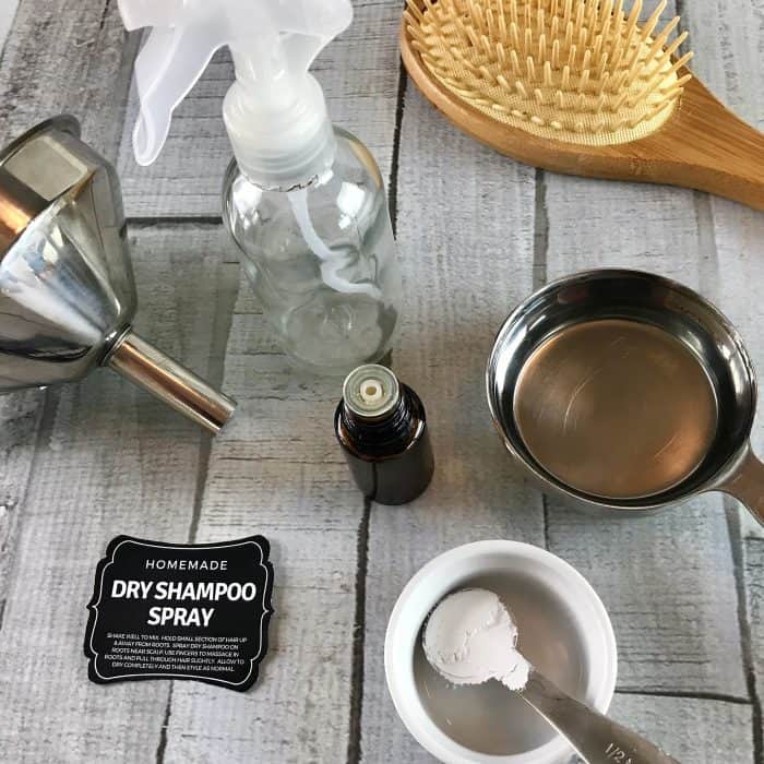 supplies to make homemade dry shampoo spray- funnel, spray bottle, vodka, calcium carbonate, essential oil