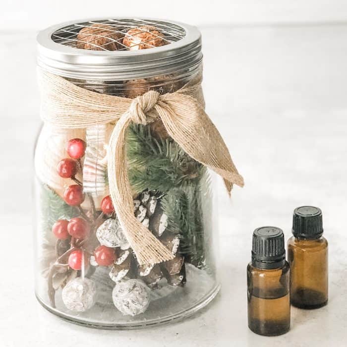 Christmas decor with berries, greenery, and pinecones used as an essential oil diffuser