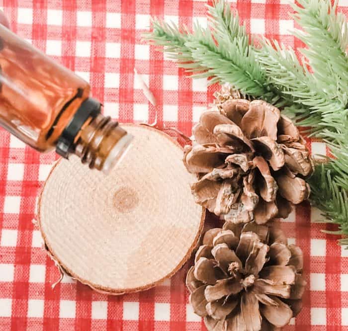 essential oil being added to wood slice for Christmas potpourri