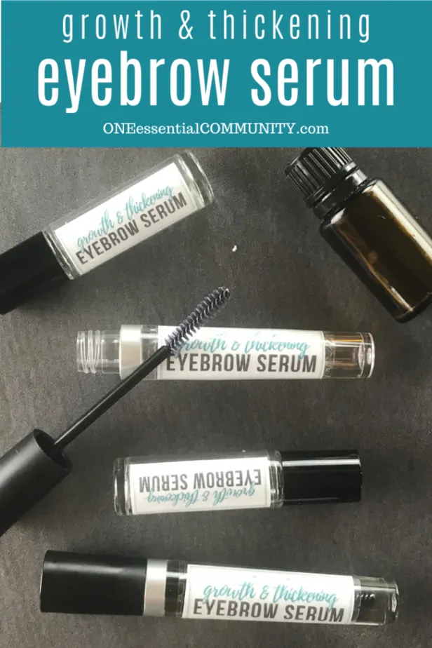 four DIY eyebrow growth serum containers on table with essential oil bottle