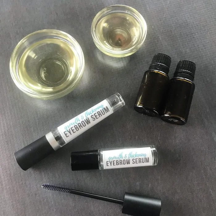 castor oil, sweet almond oil, and eyebrow growth serum containers with two essential oil bottles