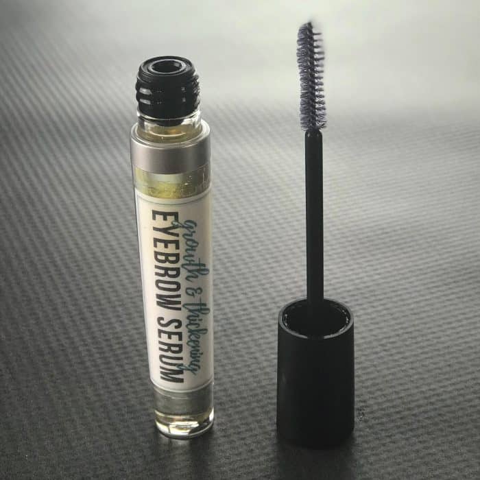 DIY eyebrow serum in mascara tube with applicator wand beside it