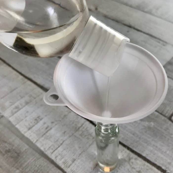 pouring fractionated coconut oil into 10ml rollerbottle