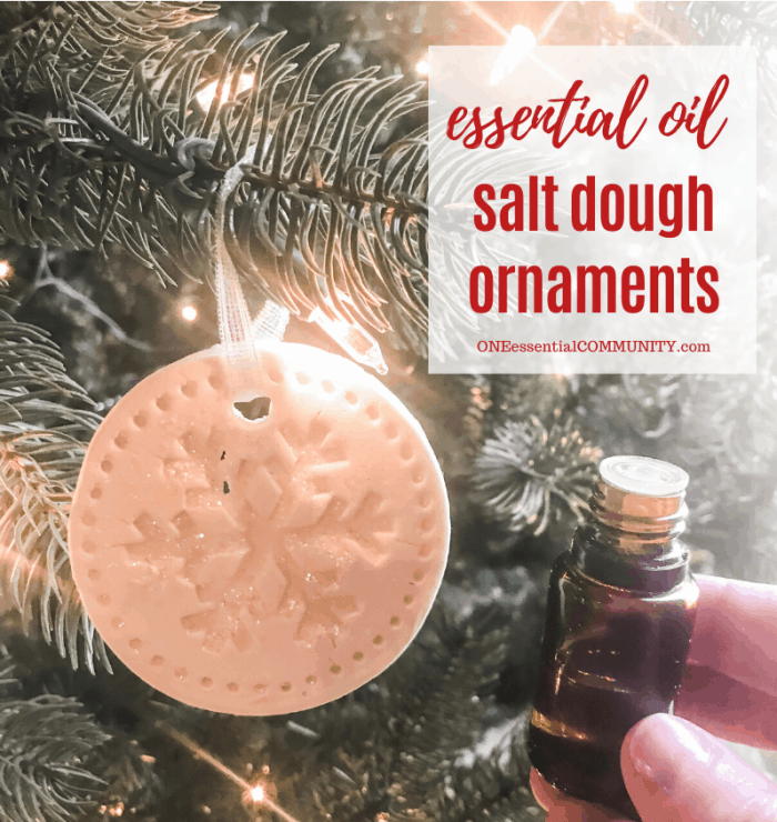 essential oil salt dough ornaments title image, snowflake-shaped ornament hanging from Christmas tree, hand-held essential oil bottle next to tree