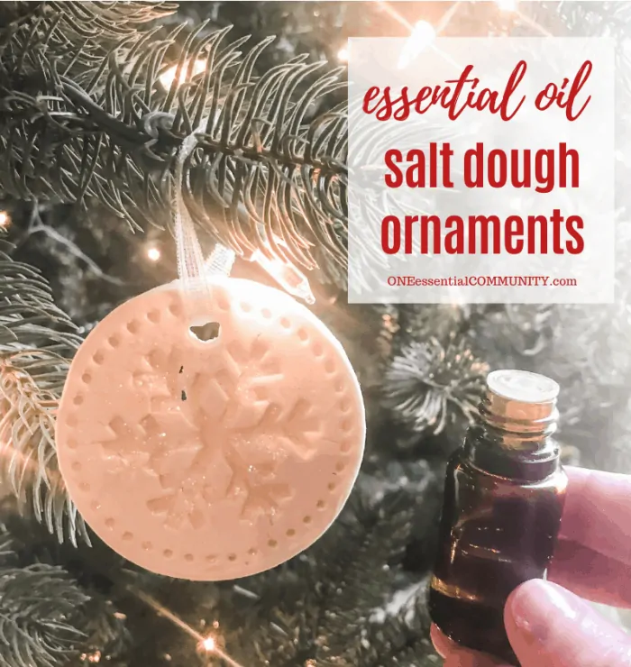 essential oil salt dough ornaments title image, snowflake-shaped ornament hanging from Christmas tree, hand-held essential oil bottle next to tree