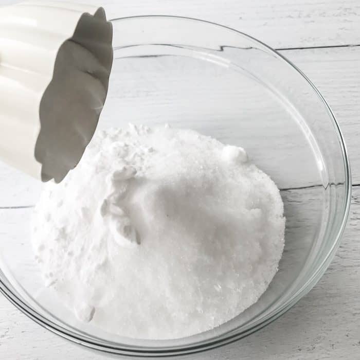 adding baking soda to Epsom salt and sea salt in glass bowl