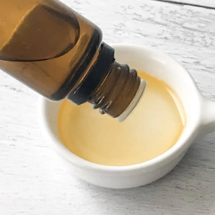 adding essential oil from bottle to apricot kernel oil