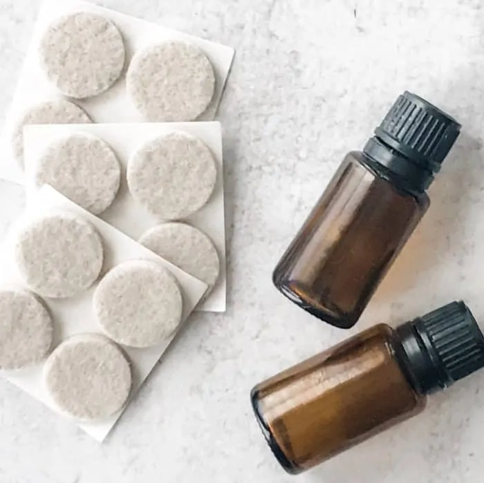 circular felt pads next to essential oil bottles, supplies for making essential oil deodorizing pads