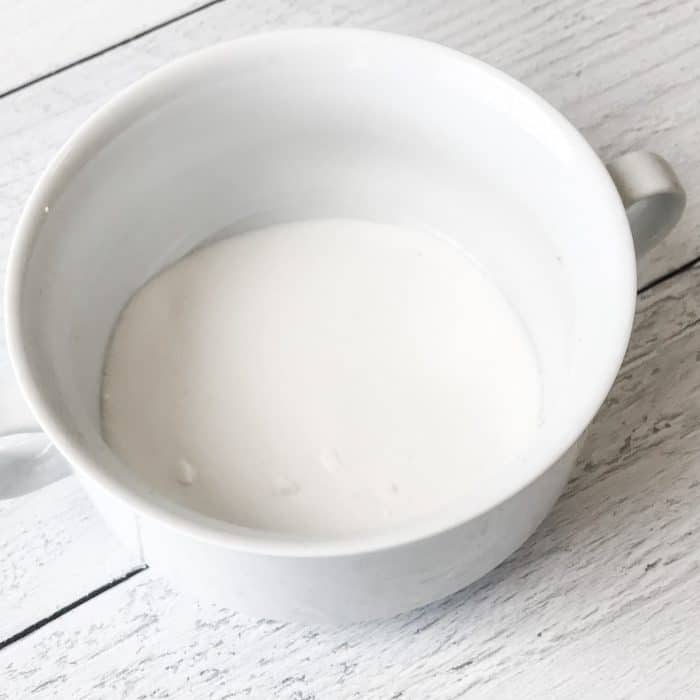 sugar added to small bowl to start making peppermint candy cane lip scrub with essential oils