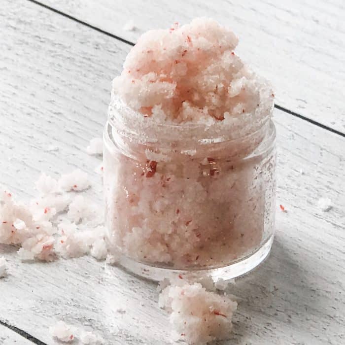 peppermint candy cane lip scrub with essential oils overflowing in small open glass jar