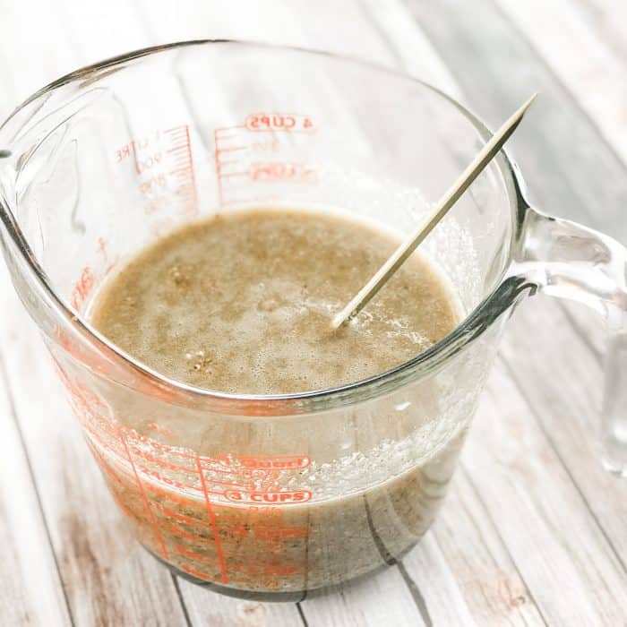 stirring in ground rice, almonds, and beans to melted cocoa butter and shea butter and lemon and lavender essential oils to make homemade Lush Buffy Bar with essential oils