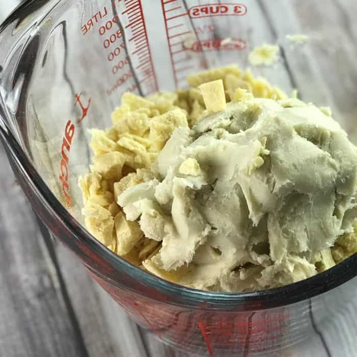 cocoa butter and shea butter in glass measuring cup ready to be melted for use in Lush Buffy Bar with essential oils