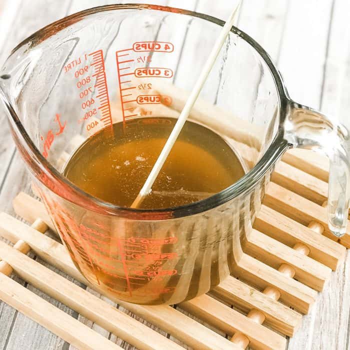 melted cocoa butter and shea butter in glass measuring cup, simmering after melting for use in DIY Lush Buffy Bar with essential oils