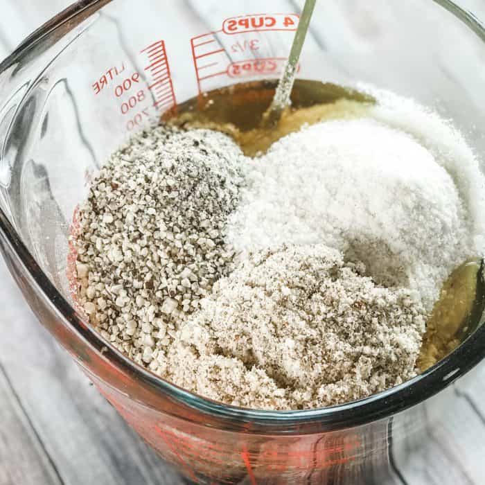 adding ground rice, almonds, and beans to melted cocoa butter and shea butter and lemon and lavender essential oils to make homemade Lush Buffy Bar with essential oils