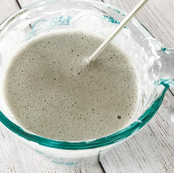 DIY clay facial soap bentonite clay stirred into goat's milk melt and pour soap and essential oil stirred with wooden skewer