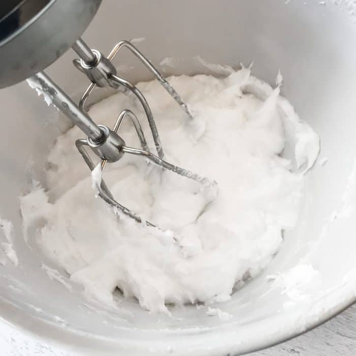 essential oil joint pain cream treat achy hands, shoulders, knees with Joyful Joints cream whipping coconut oil into cream with electric hand mixer closeup