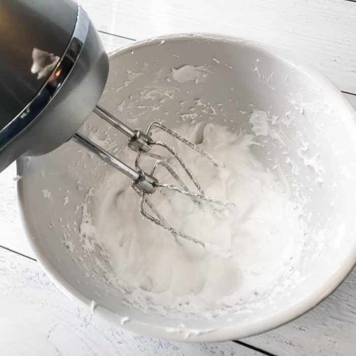 essential oil joint pain cream treat achy hands, shoulders, knees with Joyful Joints cream whipping coconut oil cream and essential oil with electric hand mixer in white bowl