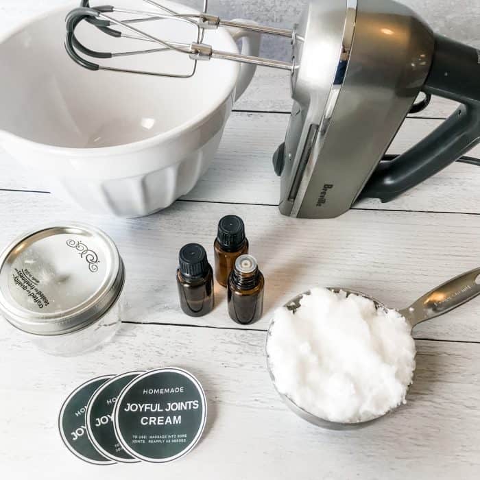 One Essential Community Joyful Joints Cream with essential oils ingredients, supplies, and tools mixer and mixing bowl coconut oil essential oils and essential oil bottles custom labels