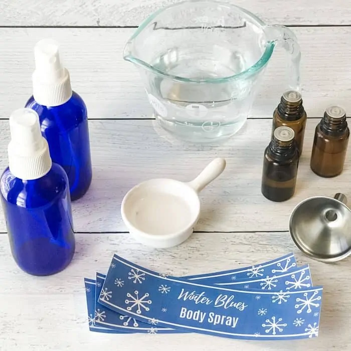 Winter Blues body spray with essential oils ingredients and materials, spray bottles, water, essential oil bottles, measuring cup, funnel, custom label