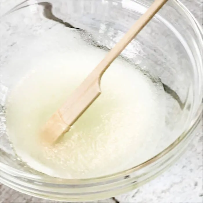 stirring DIY natural acne treatment gel mixture with essential oils jojoba oil calendula gel clear skin using essential oils
