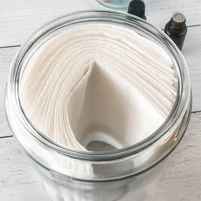 adding paper towels to jar of homemade disinfecting wipes solution