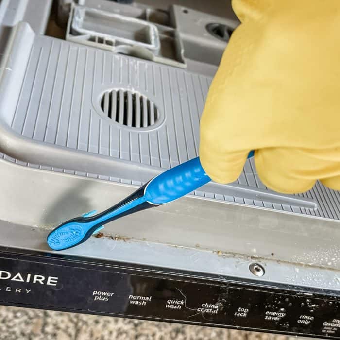 using toothbrush (or small scub brush) to clean crevices and grooves in dishwasher