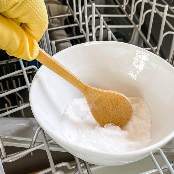 using wooden spoon to stir citric acid, baking soda, and essential oil mixture