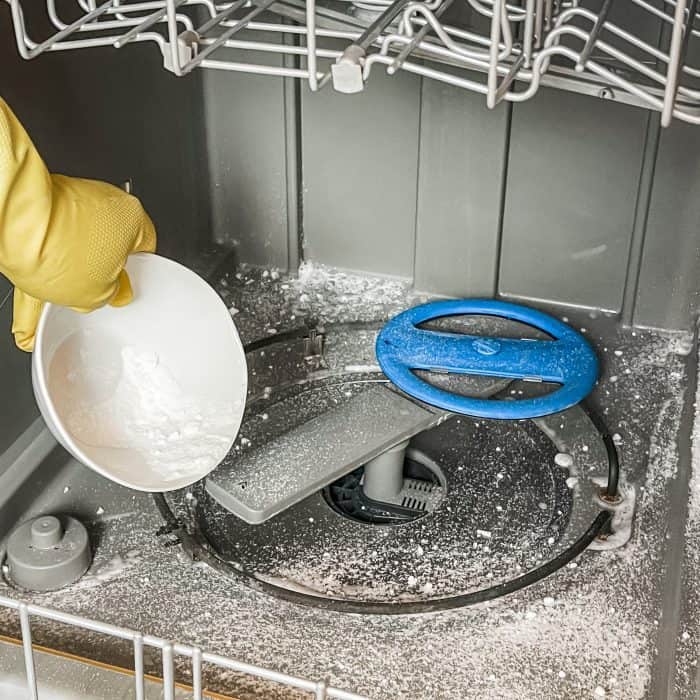 sprinkling the baking soda, citric acid, and essential oil mixture all over the bottom of the dishwasher