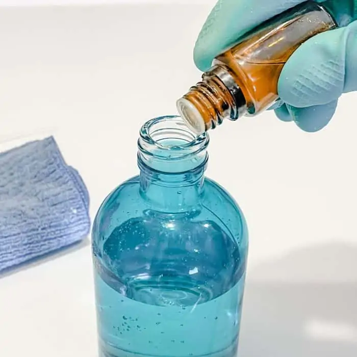 adding essential oil to DIY washing machine cleaner spray