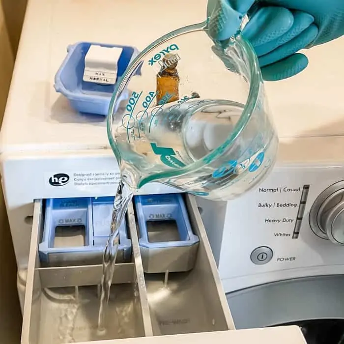 pouring vinegar into laundry detergent dispenser