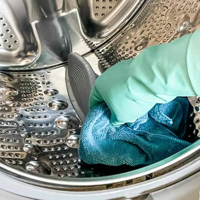 using soft microfiber cloth to clean inside of washing machine drum