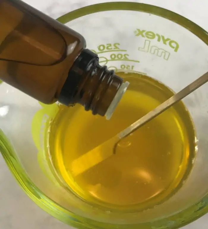 essential oil being added to melted beeswax and oils