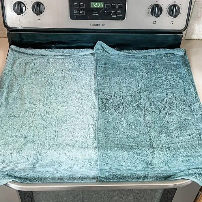 second wet towel placed over baking soda and essential oil mixture -- want to cover entire stovetop