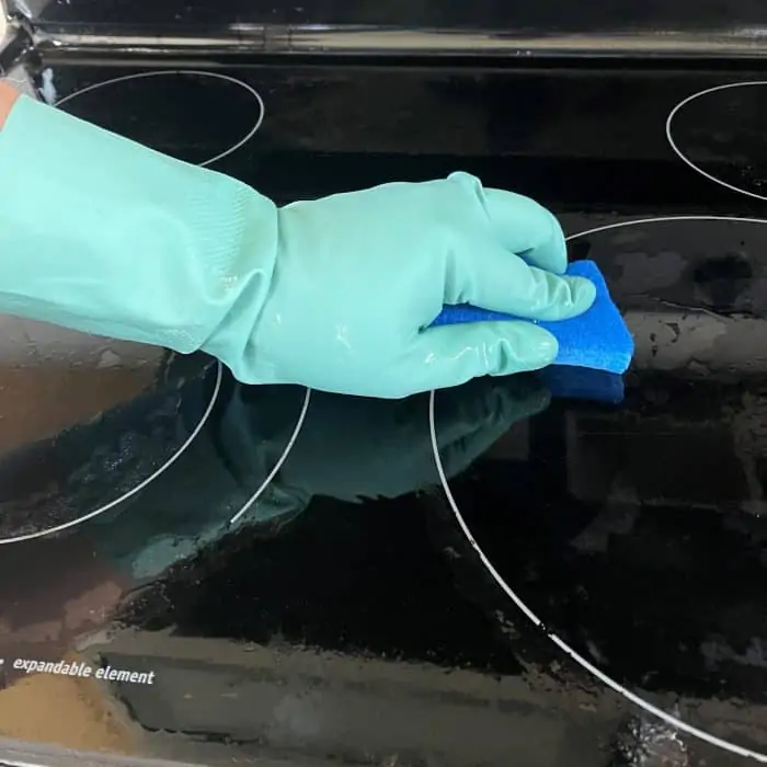 cleaning glass stovetop with sponge