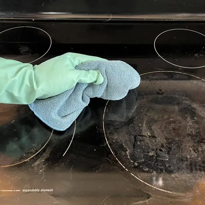 wiping stovetop clean of any loose debris